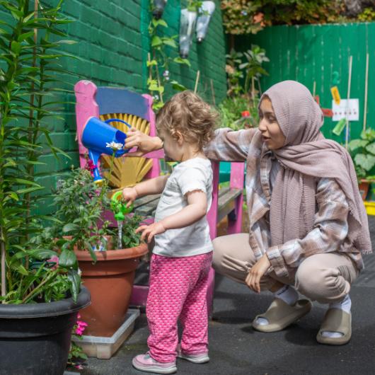 Children and nursery team together in the garden