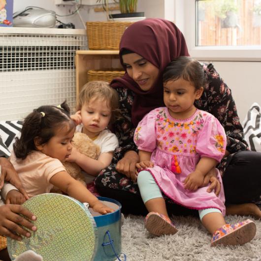 Staff and children in reading corner