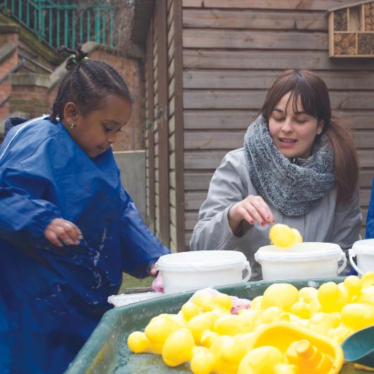 Children playing with rubber ducks in water