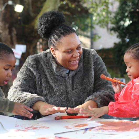 staff and two children outdoors painting