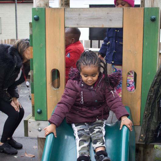 Child going down slide in playground