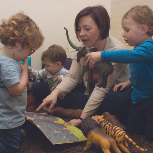 Teacher reading animal book with children