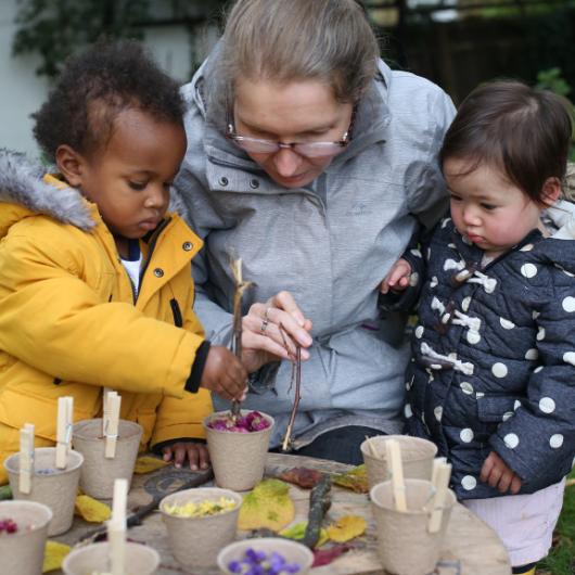 Staff member doing sustainability activity with children outdoors