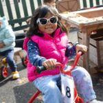 Child riding a bike outside wearing sunglasses