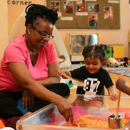 Staff and children playing with provocation with wooden spoons