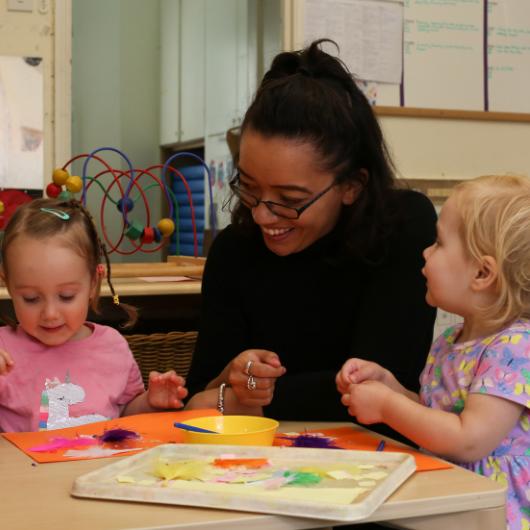 Staff member doing artwork with children