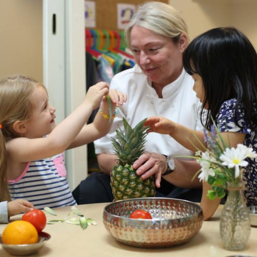 Children exploring different fruits with the nursery chef