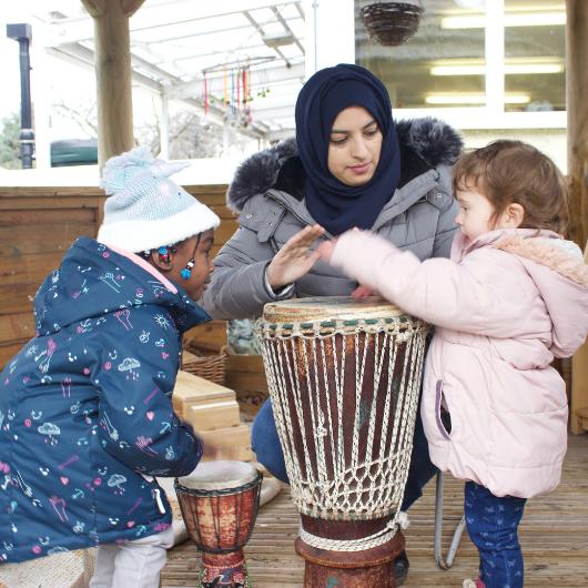 Staff and children drumming together