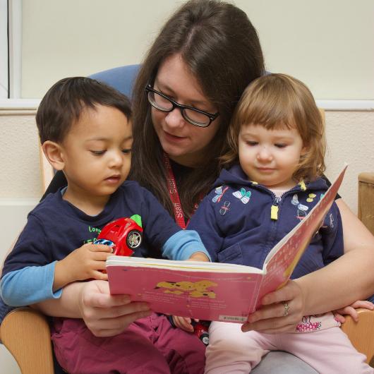 Nursery teacher reading with children