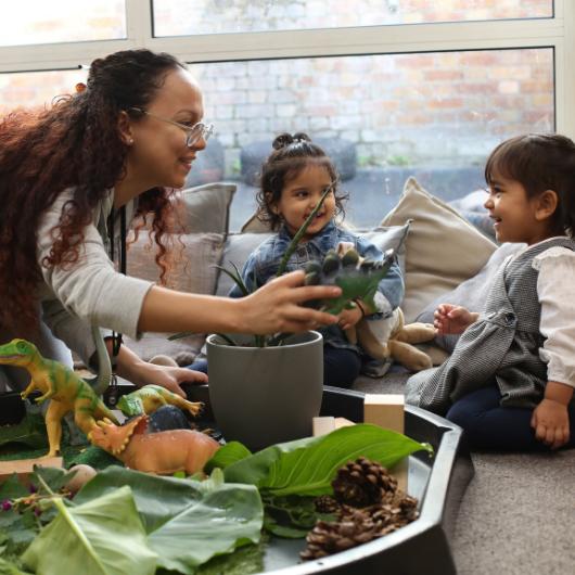 staff and children playing with dinosaurs