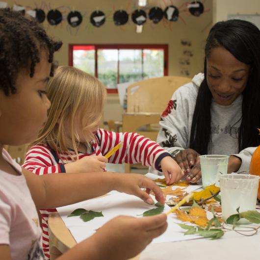 Children and teacher doing autumn craft activity