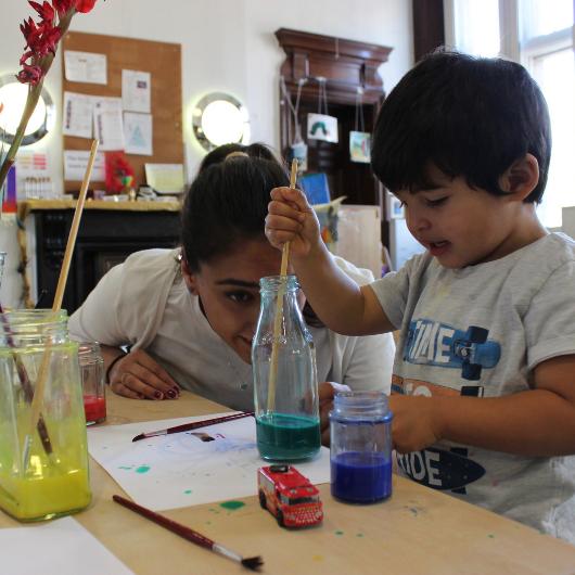 Teacher and child conducting science experiment with bottle and straw