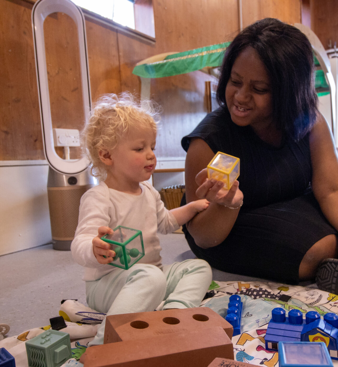Gumboots Nursery teachers plays with child