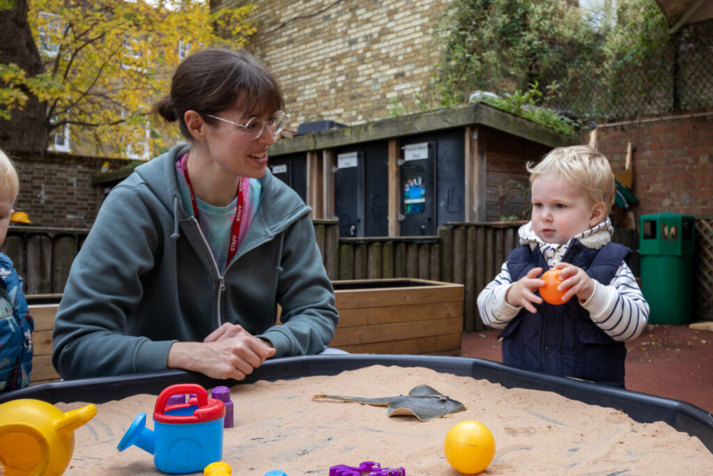 Teacher and child playing with sand at LEYF Micky Star