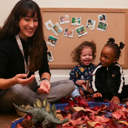 Children and staff playing with leaves