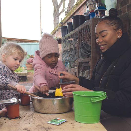 children and staff planting some seeds to grow flowers