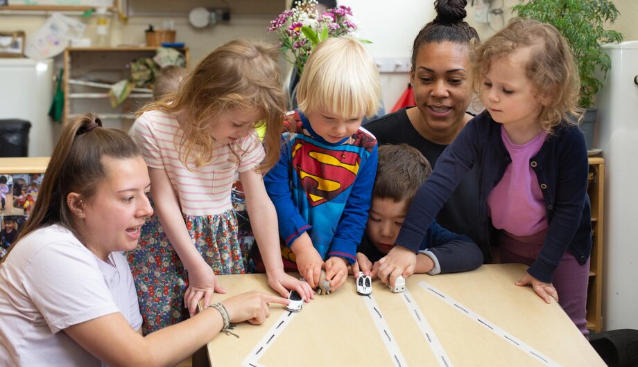 Teachers and children racing toy cars