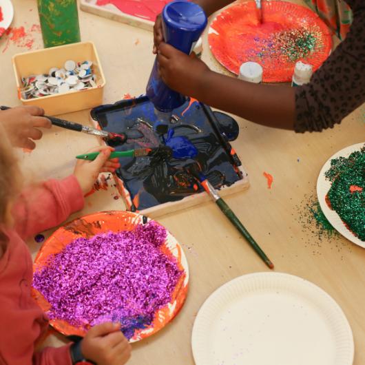 children getting involved in messy play with glitter and paint