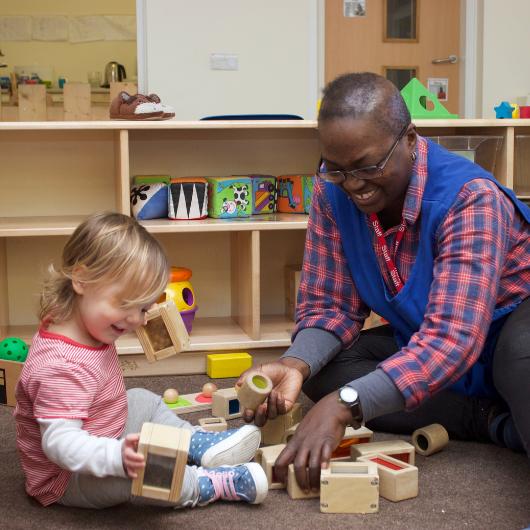 staff and child using building blocks