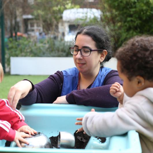 children and staff playing with soil