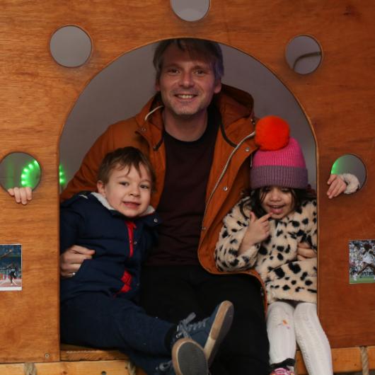 Male member of staff in the garden with children, posing and smiling at the camera