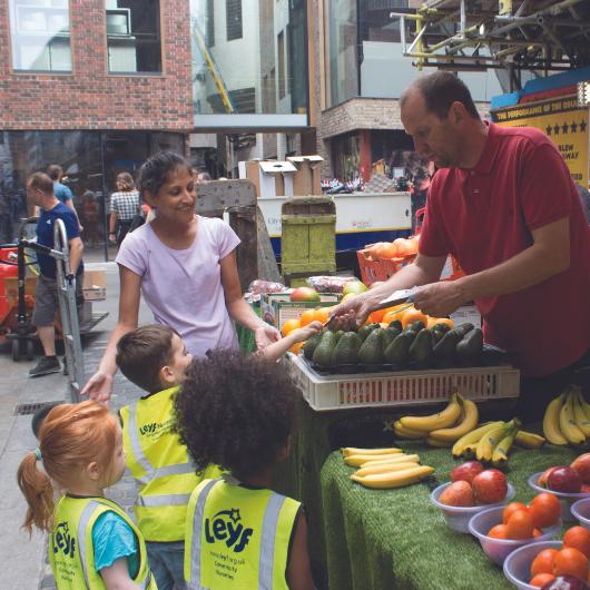 Children going to the local market with a member of staff to buy some fruits