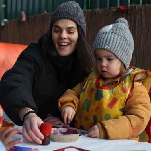 Staff and child outside painting