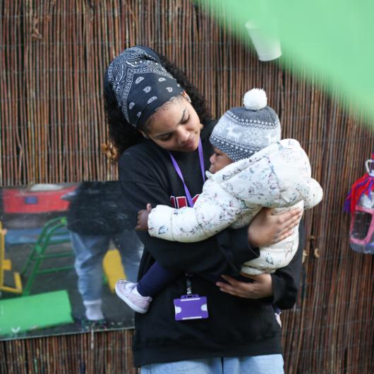 Staff holding child showing affection and nurturing