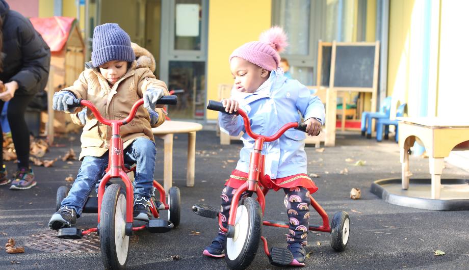 Children outside in the garden riding their bikes