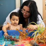 Staff and child playing with animals