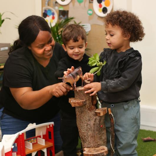 Staff and child using little animals to play