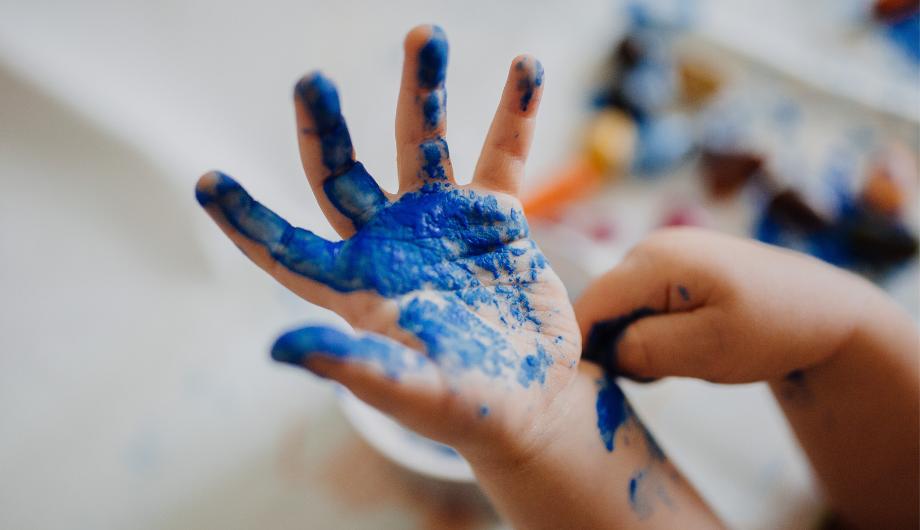 A child's hand being painted by the child