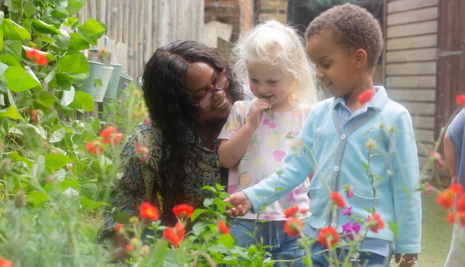 Children looking at flowers with teacher