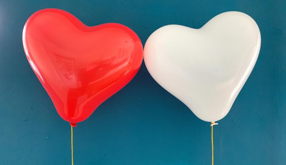 Two balloon hearts, one red, one white