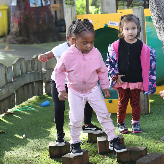 Children walking on wooden stepping stones