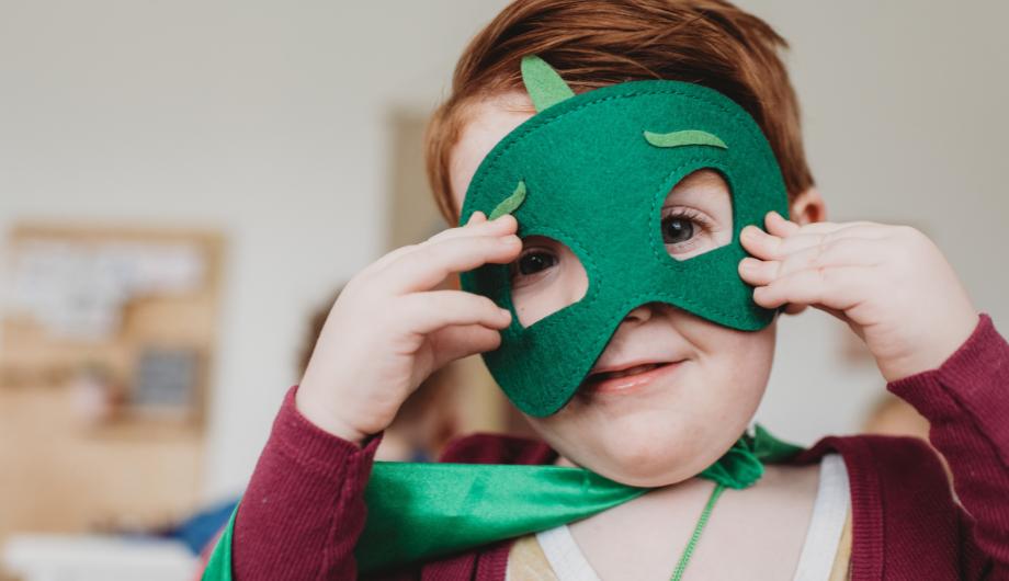 Boy wearing costume with green mask