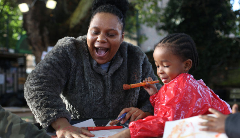 staff and child painting outside