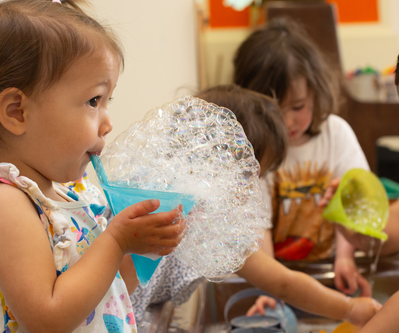 Photo of a child blowing bubbles using a bubble maker