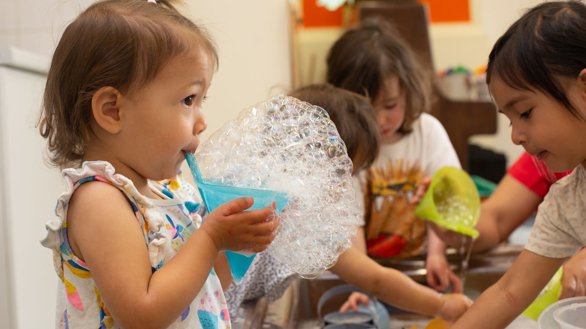 Photo of a child blowing bubbles using a bubble maker