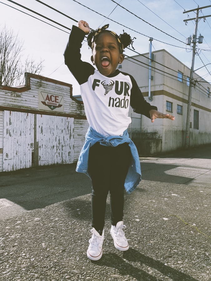 Child shouting and jumping wearing a T-shirt which says Fournado on it