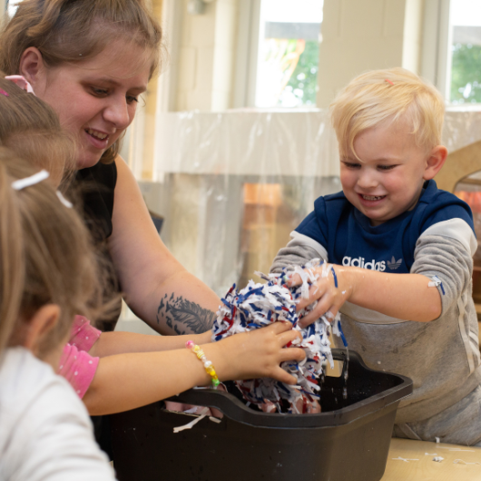 staff and children using paper and water to create a paper mash