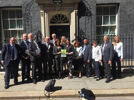 A group of people stood outside 10 Downing Street presenting a report