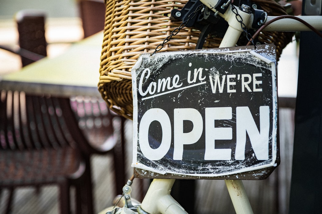 Sign hanging from a bicycle saying Come in We're Open