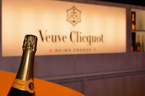 A bottle of champagne in front of the Veuve Cliquot logo