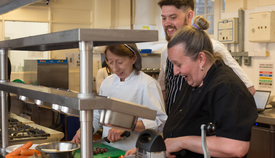 Chefs chopping food in kitchen in Chef Academy training