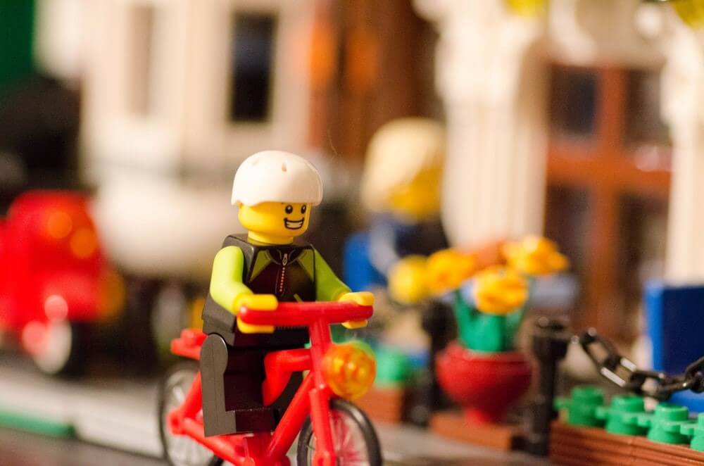 Lego figure riding a red lego bicycle