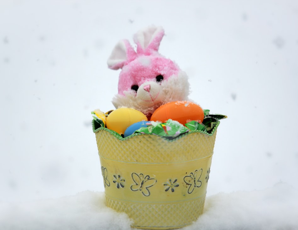 Image of a pink bunny inside a yellow bucket surrounded by eggs