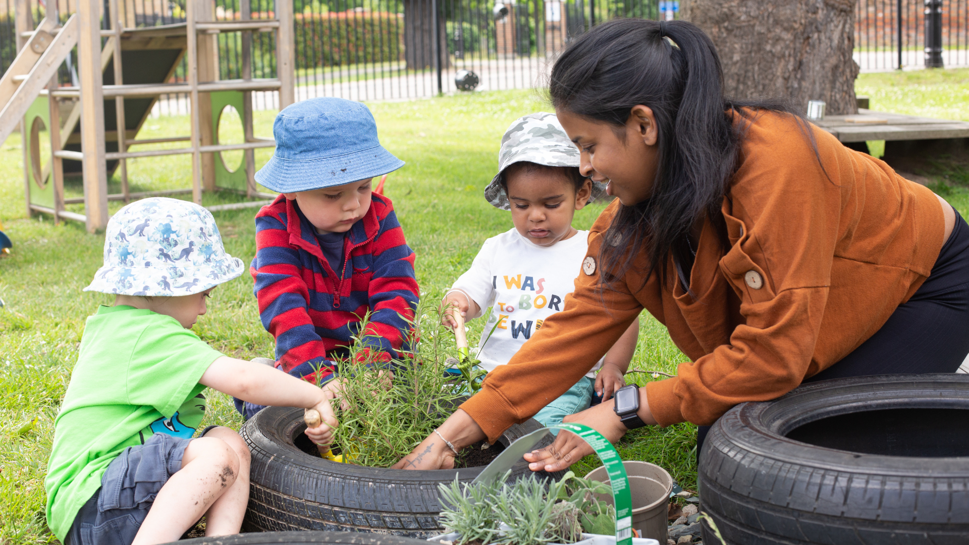 A teacher and children at Bushy Tails gardening