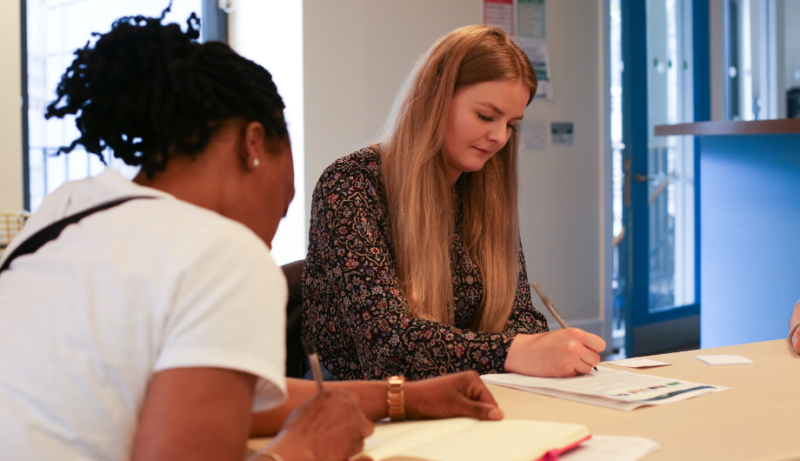 Member of staff writing notes down