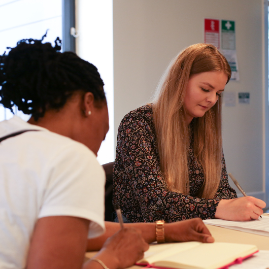 Member of staff writing notes down